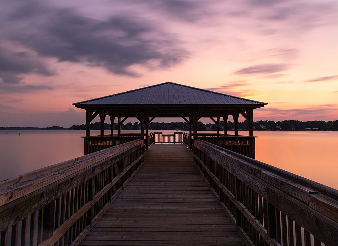 About Our Agency - Covered Deck on a Lake at Sunset