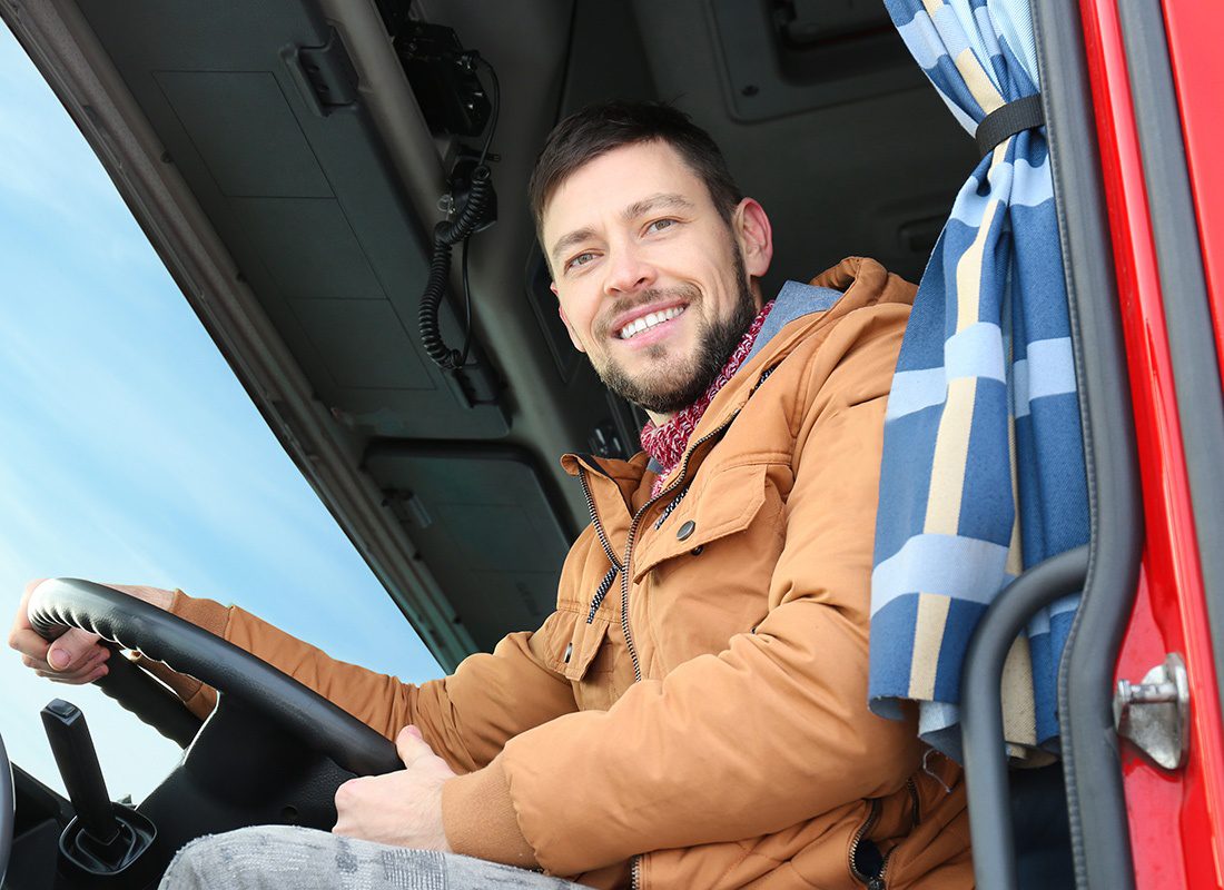 Business Insurance - Truck Driver Sitting in His Cab Smiling, Seen From Below